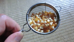 ポップコーンの種、茶こしで計る。