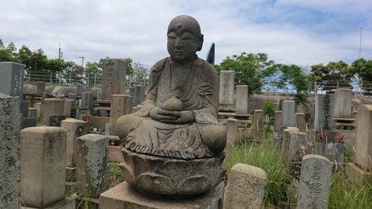 墓地の地蔵菩薩。両手で宝珠を持つ