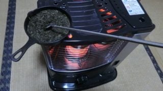 ストーブの上の茶葉（茶香炉）をかき混ぜる