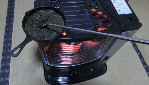 ストーブの上の茶葉（茶香炉）をかき混ぜる